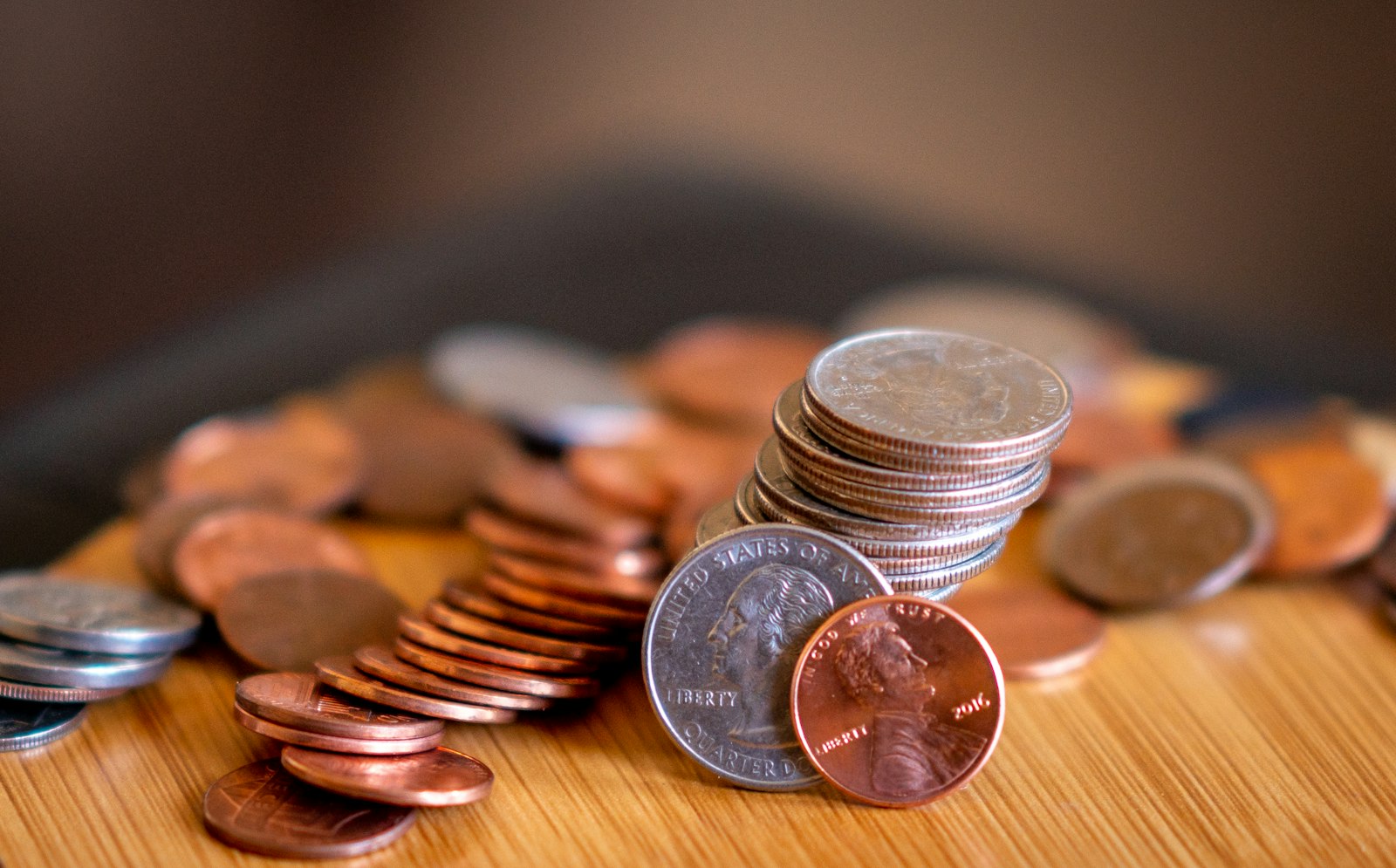 United States quarters and pennies on a wooden table