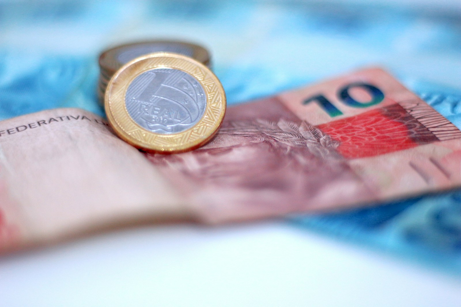 A coin resting on a pile of banknotes